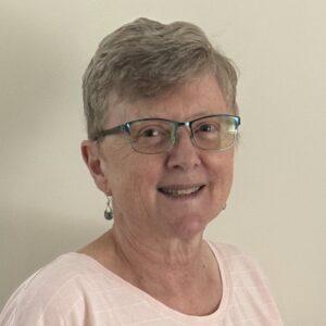Headshot of Clare O'Donoghue, a white woman with glasses and short gray hair.